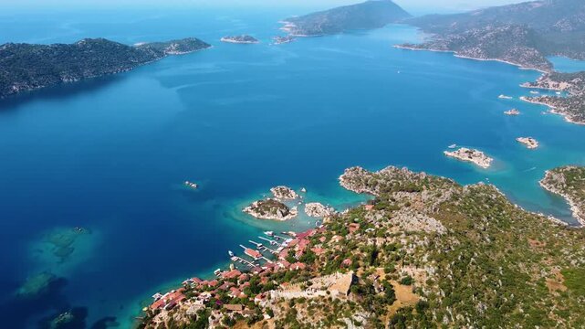 An aerial drone shot captures the beauty of Simena Castle Kalek&ouml;y and the tranquil turquoise waters surrounding Kekova Island in Antalya, Turkey. This footage showcases the historic castle ruins nestl