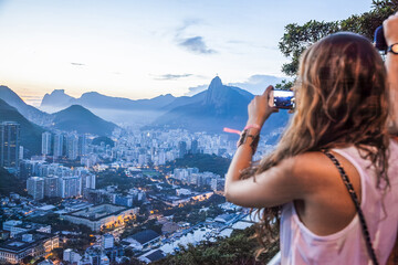 Blurred tourist capturing rio de janeiro city view with smartphone