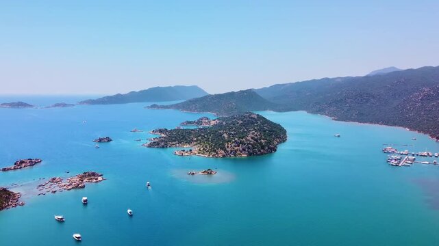 aerial drone shot captures the historic Simena Castle Kalek&ouml;y overlooking the stunning turquoise waters of Kekova Bay on the Mediterranean coast of Turkey.