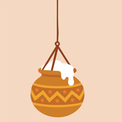 Hanging decorative pot with intricate patterns and white substance, suspended by a rope against a soft pastel background, showcasing traditional craftsmanship and cultural significance