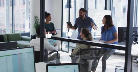 Presenter outlining on tablet in glass business meeting, thumbs up icons floating and team clapping - Powered by Adobe