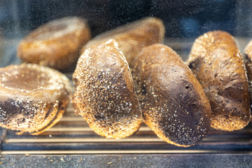 Oval rye bread with seeds in boxes on the counter in the store.