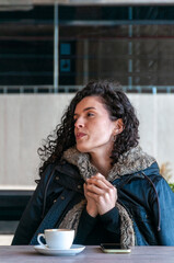 Adult woman sitting with coffee cup in modern café
