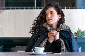 Young woman relaxing with coffee cup at café table