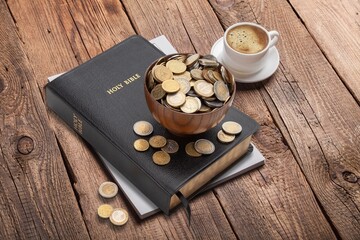Golden coins and Holy Bible book on the desk