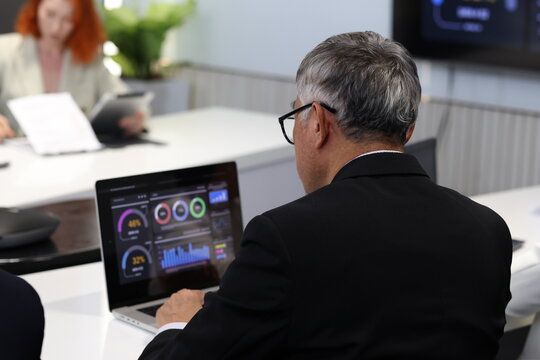 Diverse Team Working Together in Modern Co-Working Space. Casual meeting of senior diverse business team analyzing financial data. Multiethnic business people working in the office. senior man. - Powered by Adobe