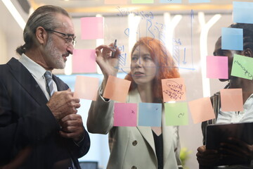 Diverse Team Working Together in Modern Co-Working Space. Casual meeting of senior diverse business team analyzing financial data. Multiethnic business people working in the office. senior man.