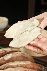 Hand Holding Fresh Sweet Potato Slices with White Fluffy Interior for Cooking