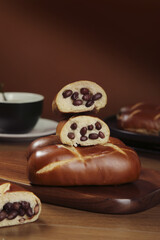 Sweet Red Bean Filled Bread Roll Sliced on Wooden Board with Coffee Cup