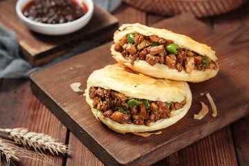Chinese Steamed Pork Buns with Meat Filling and Sauce on Rustic Wooden Serving Board