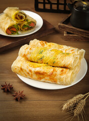 Ham and Egg Breakfast Crepes with Vegetables on Rustic Wooden Table
