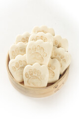 Bear paw shaped natural soap bars in wooden bowl on white background