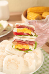 Cute Bear Paw Glove Holding Breakfast Sandwich with Bacon Egg and Fresh Ingredients