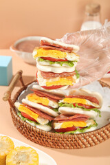 Stack of Popular Breakfast Sandwich Wraps with Eggs and Bacon in Wicker Basket