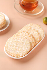 Japanese Senbei Rice Crackers with Tea - Traditional Crispy Snacks on Pink Background