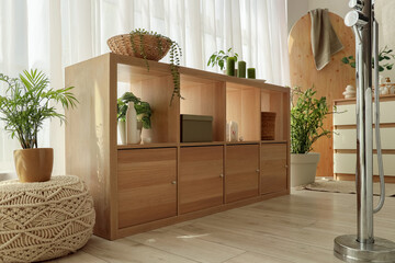 Shelf unit with bath supplies and plants in room