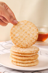 Crispy Rice Cakes Stack with Hand Reaching for Healthy Snack on White Plate