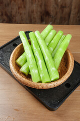 Fresh Green Celery Stalks in Bamboo Basket on Wooden Board - Healthy Organic Vegetable Ingredient