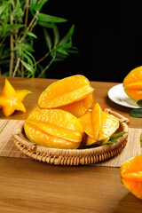 Fresh Yellow Star Fruit Slices in Wicker Basket on Wooden Table