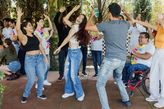 group of latin friends dancing in a party in terrace outdoors in Mexico Latin America. Hispanic people men and woman multi age having fun - Powered by Adobe
