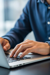 Close up of hands typing on a laptop keyboard