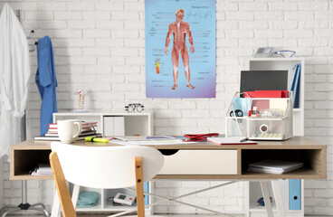 Medical student's workplace with stationery and coffee cup in clinic