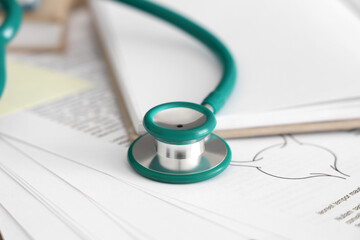 Stethoscope with study materials on medical student's table, closeup