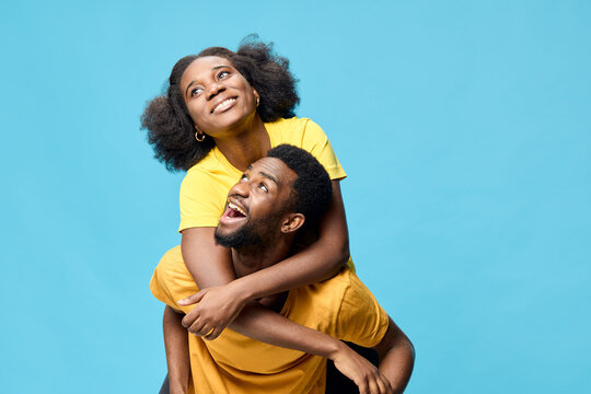 Fototapeta Joyful couple in matching yellow outfits against a vibrant blue background, exuding happiness and love, perfect for seasonal campaigns and lifestyle themes