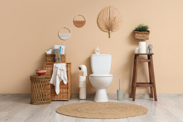 Interior of restroom with toilet bowl, stool and baskets