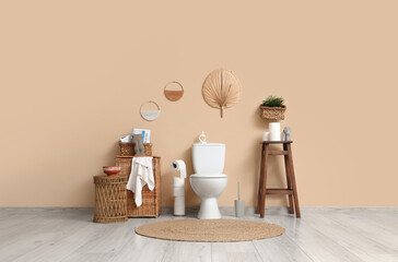 Interior of restroom with toilet bowl, stool and baskets
