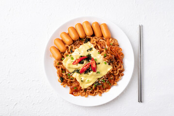 Top view of Korean spicy instant noodles with kimchi, sausage and Mozzarella cheese on white background