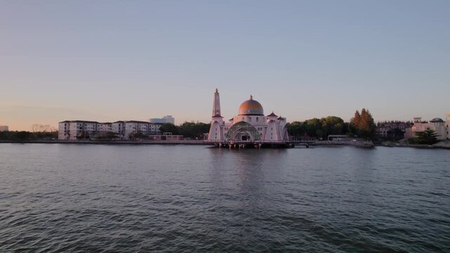 Drone footage of Masjid Selat floating mosque at golden hour, highlighting its position above the water in Melaka, Malaysia