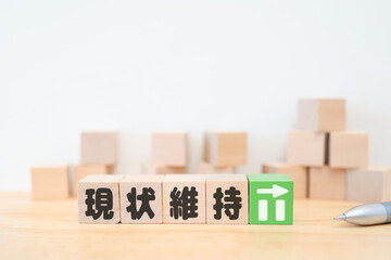 現状維持を示す木製ブロックとグラフ