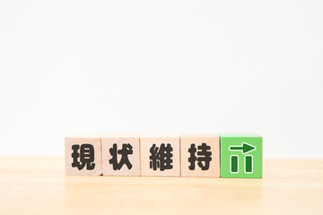 現状維持を示す木製ブロックとグラフ