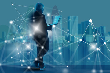 Businessman with laptop standing in front of digital network connections and city skyline, representing technology, innovation, communication. Information Technology.