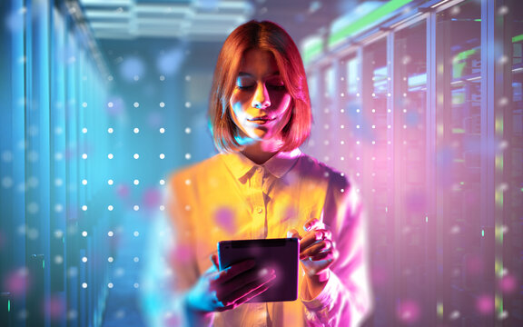Woman using tablet in modern data center with digital light effects, managing servers and cloud technology, innovation in IT. Information Technology.