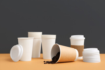Disposable cups of coffee on grey background