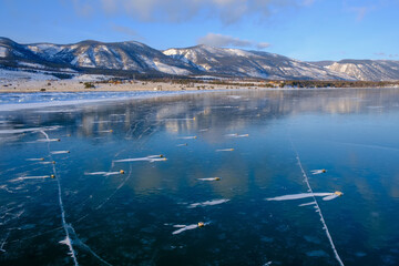 Baikal Lake in winter. Beautiful landscape with mountains reflected in ice of frozen Small Sea