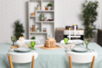 Stylish table setting for dinner in kitchen, blurred view