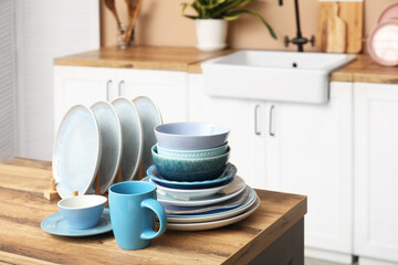 Clean blue dishes on wooden table in kitchen