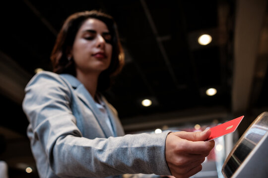 Woman paying for transaction using red credit card at checkout - Powered by Adobe