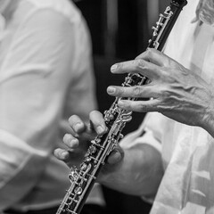 Close-up of musician's hands playing oboe in black and white