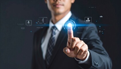 A well-dressed man in a tailored suit stands confidently, pointing to a large, shiny button on his finger, showcasing a blend of style and innovation.