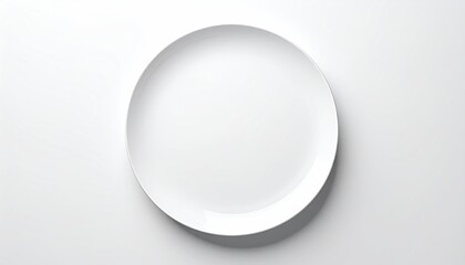Overhead shot of a plain, white, circular plate with a shadow, on a white surface