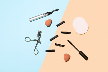 False eyelashes with sponges, curlers and mascara brush on color background