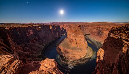 A dramatic panorama of a horseshoe-shaped canyon under a full moon. The sky is clear and starry