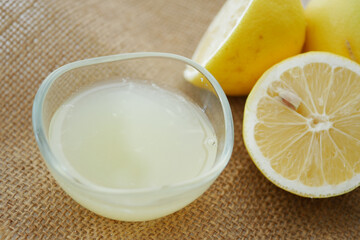 Freshly squeezed lemon juice in a bowl with halved lemons