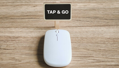 TAP & GO Message on Mini Chalkboard Above a Computer Mouse Representing Contactless Payment Technology