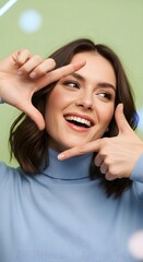 Fototapeta premium Woman framing face with hands against green background - portrait concept for self-expression and creativity