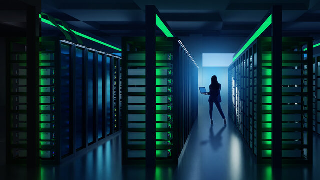 Woman with laptop walking through data center corridor with glowing server racks, managing cloud computing and cybersecurity operations, Information Technology.